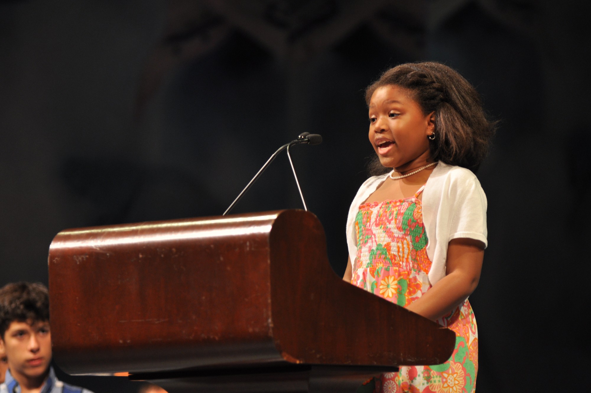 Elementary school student performing her speech behind a podium on stage at Ford’s Theatre.