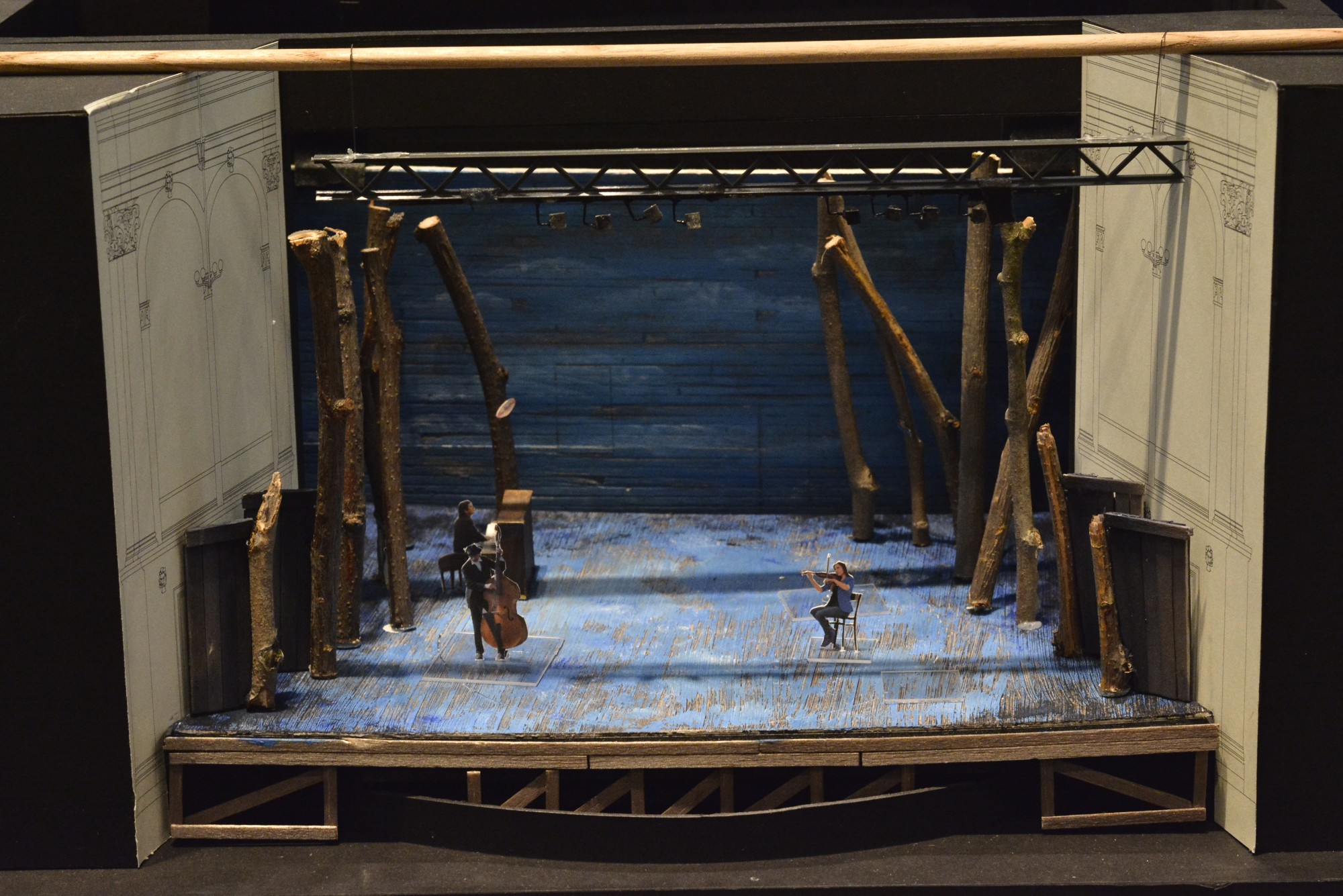 A model of a stage with cardboard people representing actors.