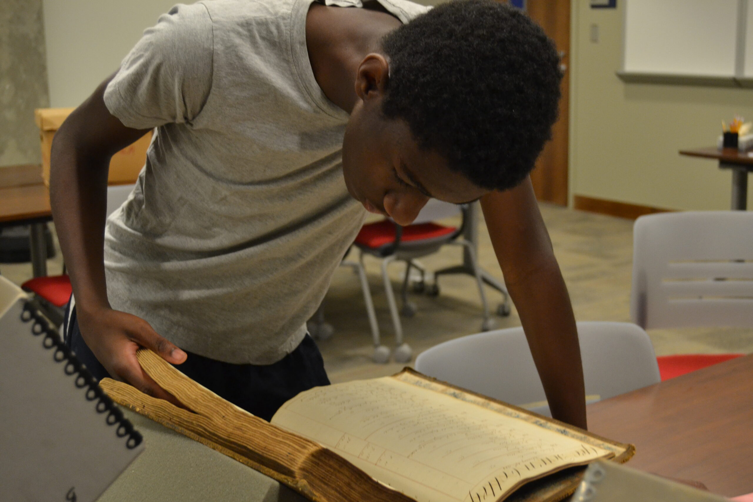 A student looks through a historical ledger in the Georgetown University archives.