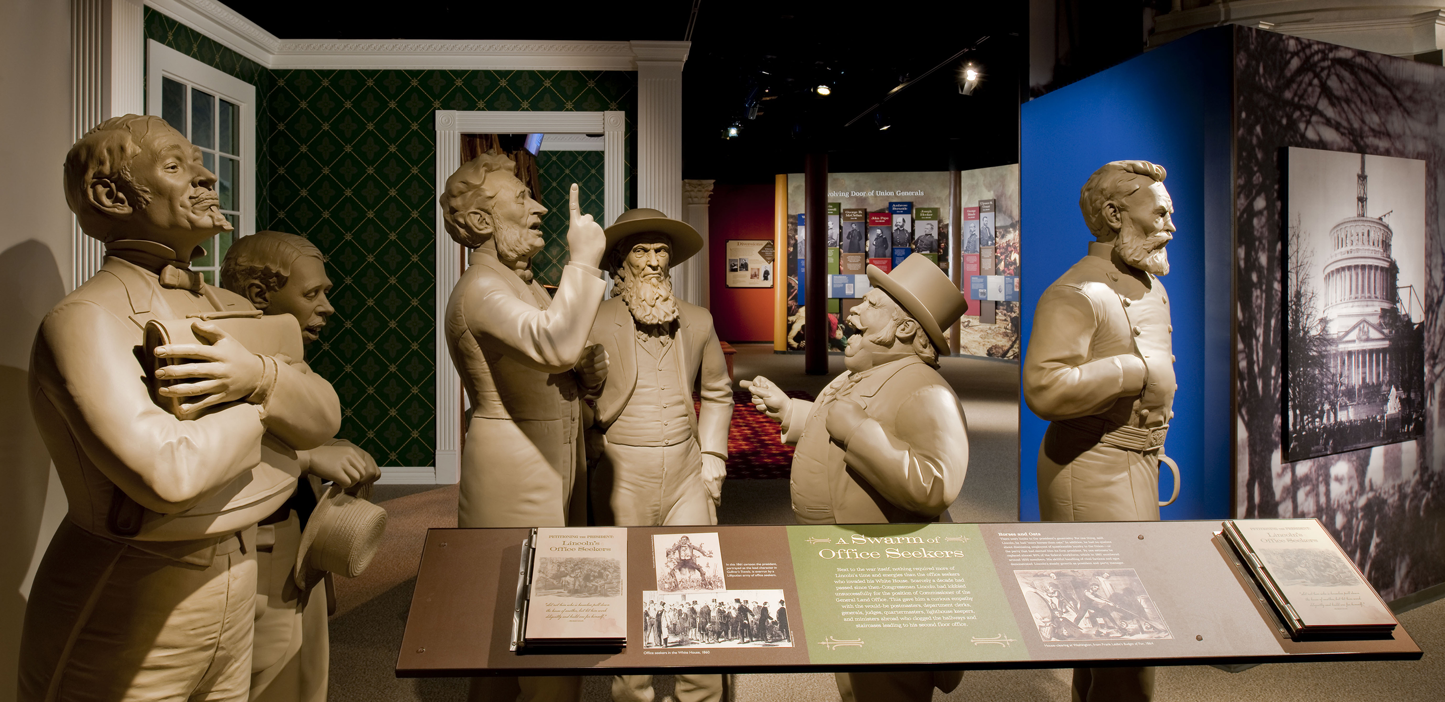 A museum display of six all-white statues of men from the 1860s, which represent the jobseekers and visitors to the Lincoln White House. In the center, a man in a suit raises a finger as he speaks. Opposite him, a short man in a top hat is pointing to him with his mouth open, as if they are engaged in a debate.
