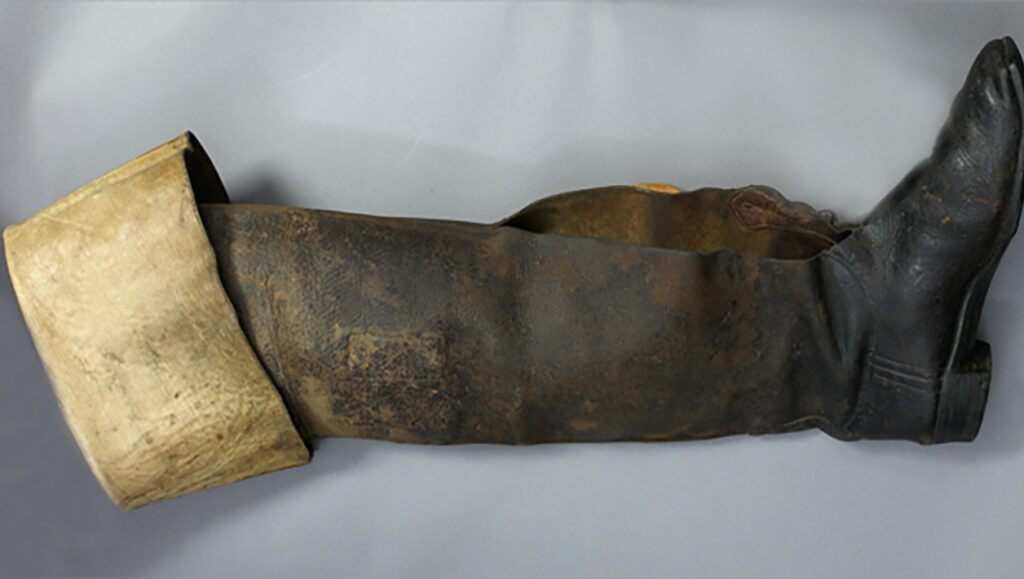 A photograph of a muddy knee-high boot.